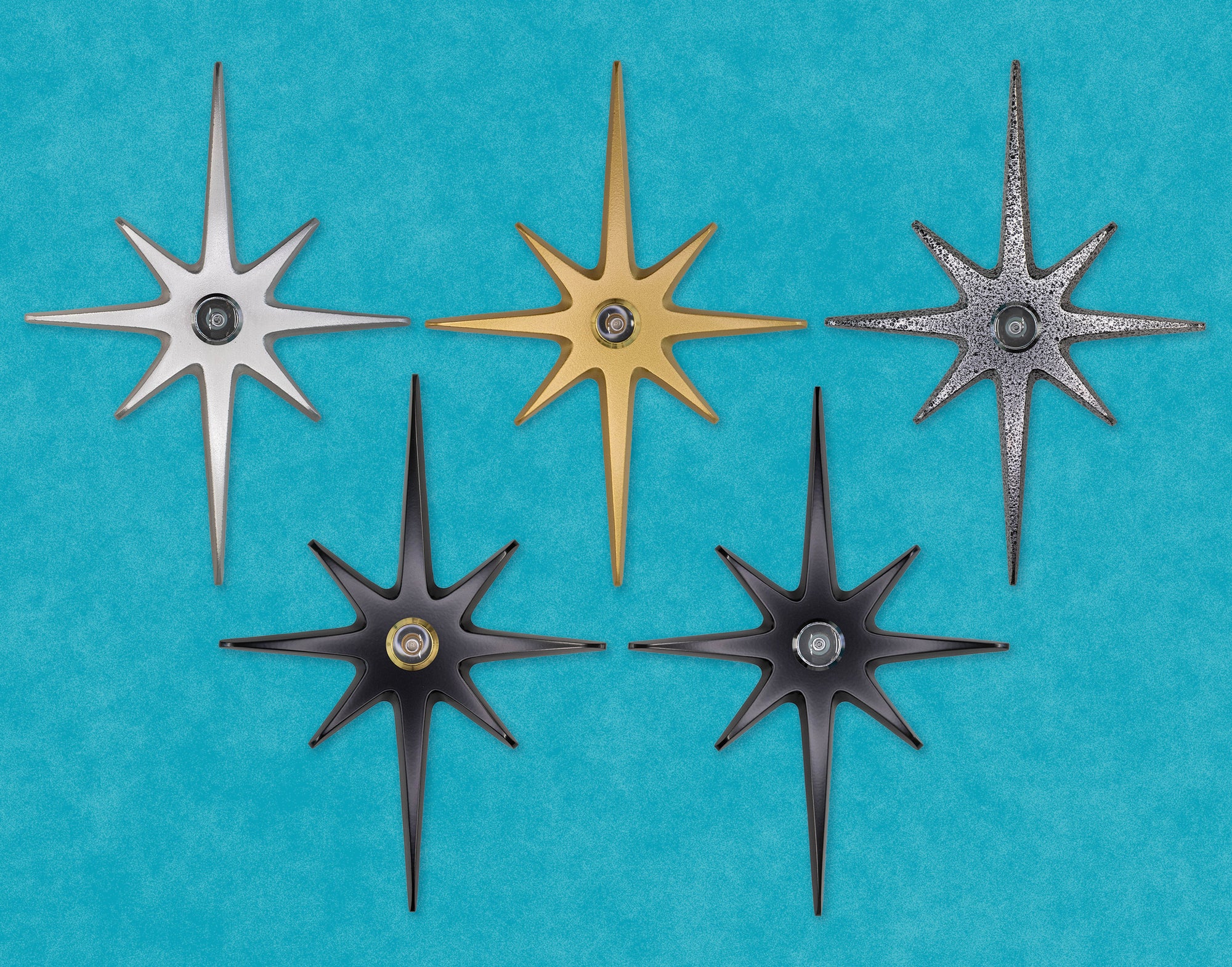 A group photo of all 5 variations of the product: a large starburst with a peephole in the center. The colors are silver, gold, black, and black frost.