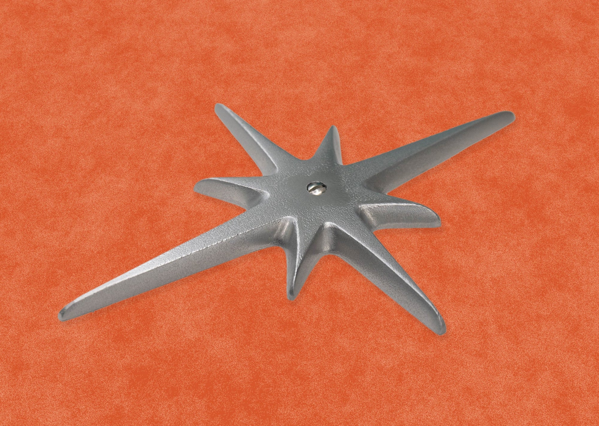 A closer view of the medium starburst with a single screw at its center. You can clearly see the slightly porous texture on the surface, but it still has a very nice smooth silver shine. The edges of the starburst points are nicely rounded off.