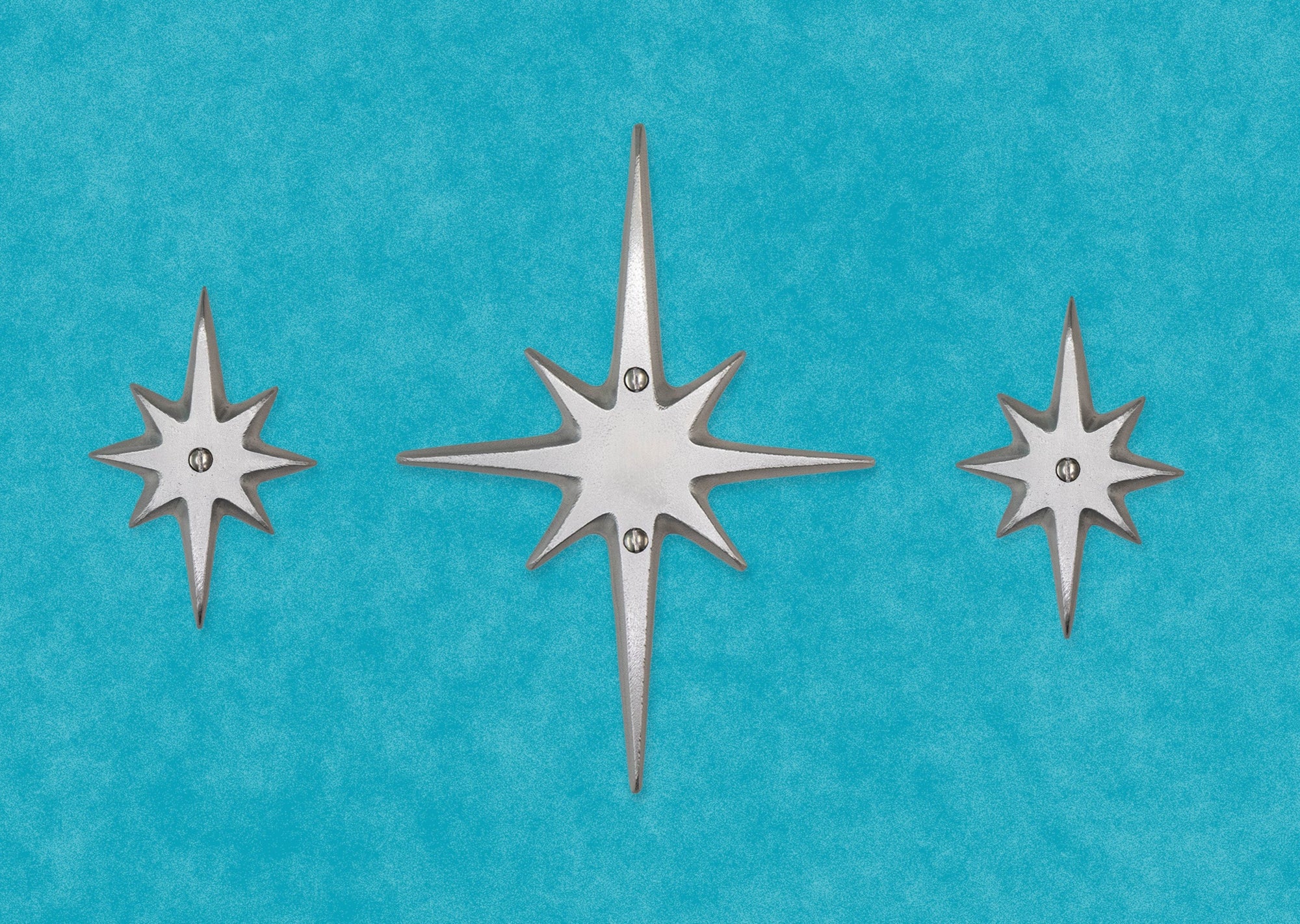 The set of three without the peephole viewer. The center medium starburst has two screws in top and bottom of the center area. Two small starbursts are on either side, each with a single screw in their center.