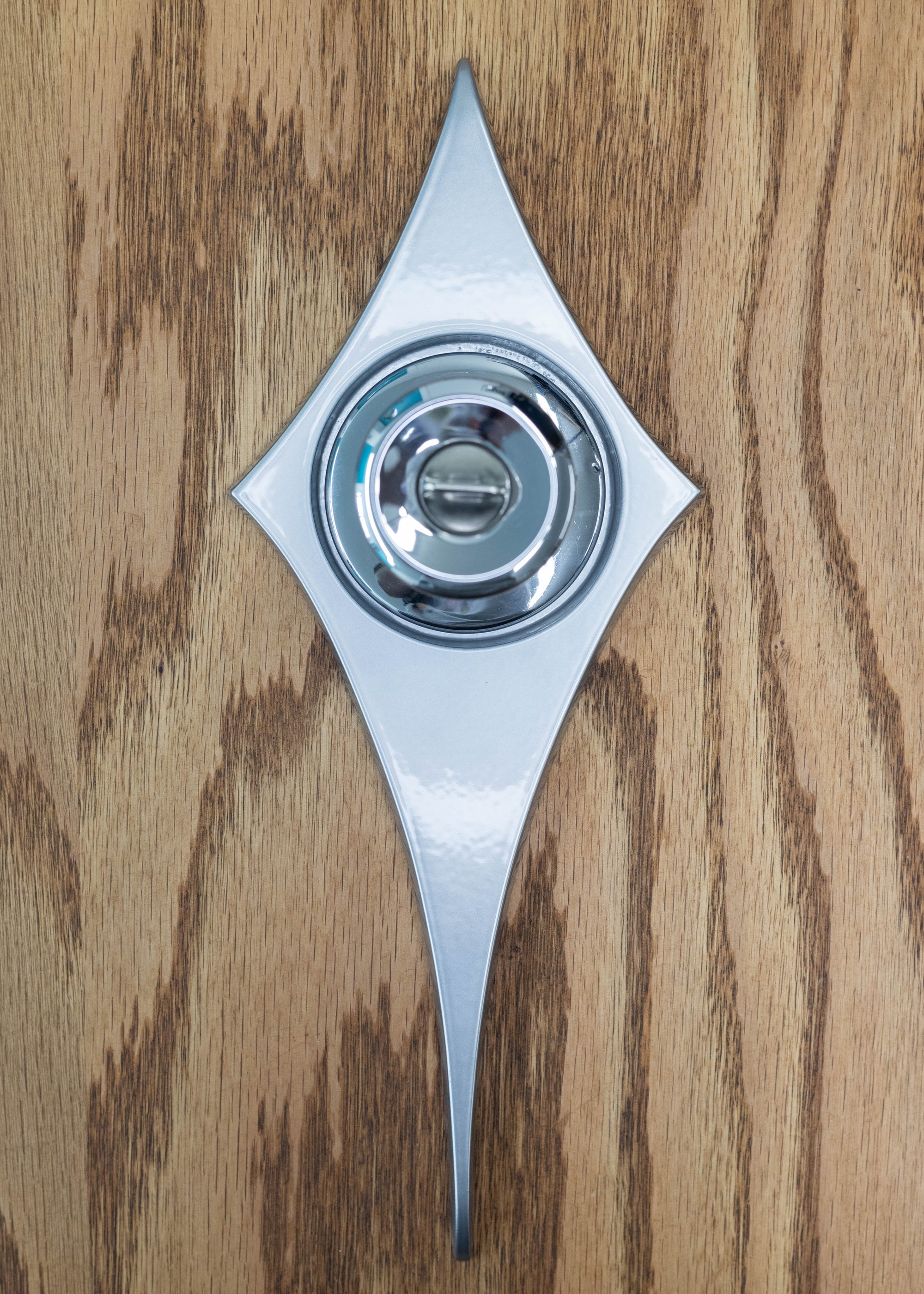 The silver escutcheon pictured with a chrome doorknob.