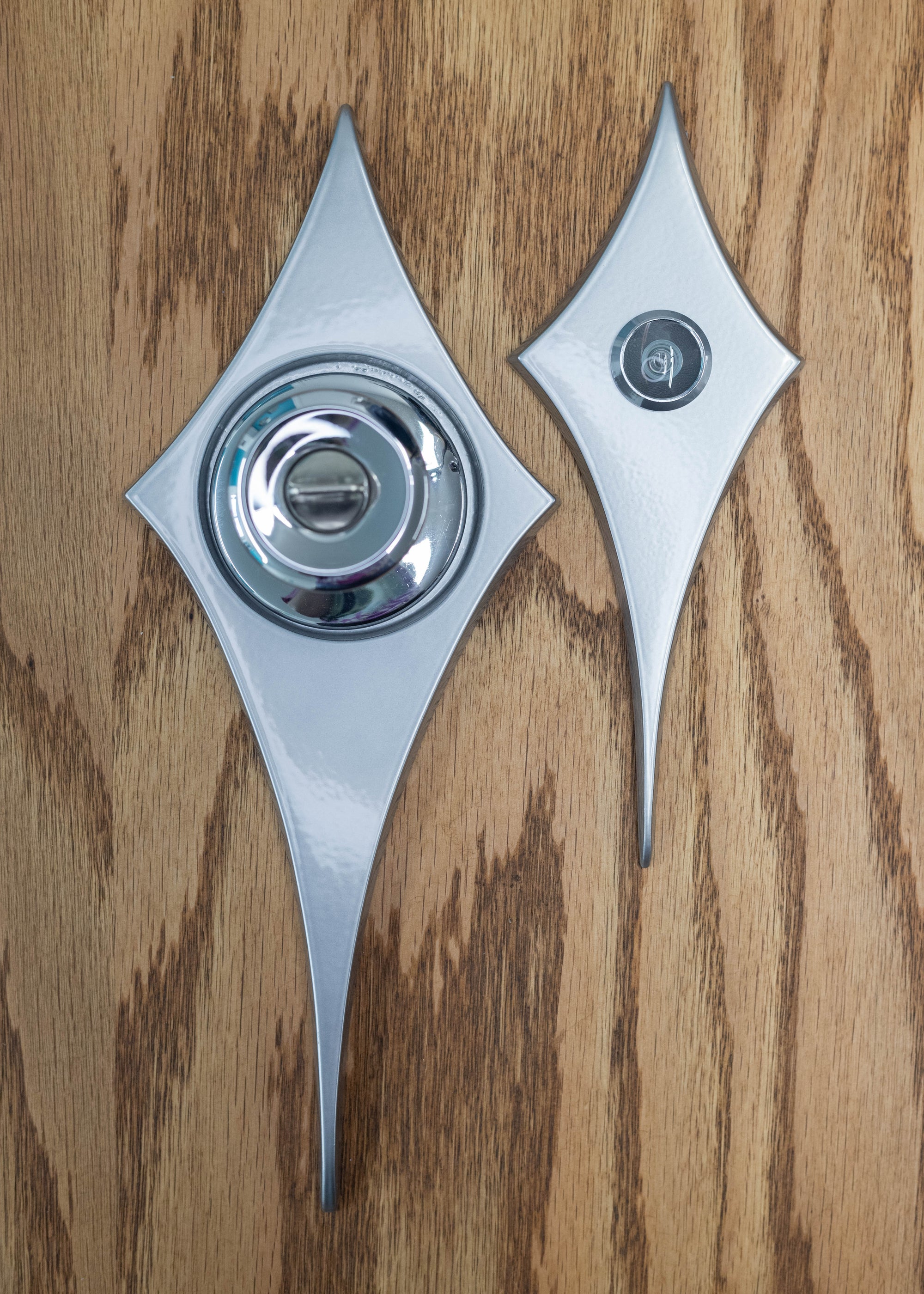 The comet peephole viewer and comet doorknob escutcheon next to each other to compare the sizes. The peephole viewer is about a bit over half the size of the doorknob escutcheon.