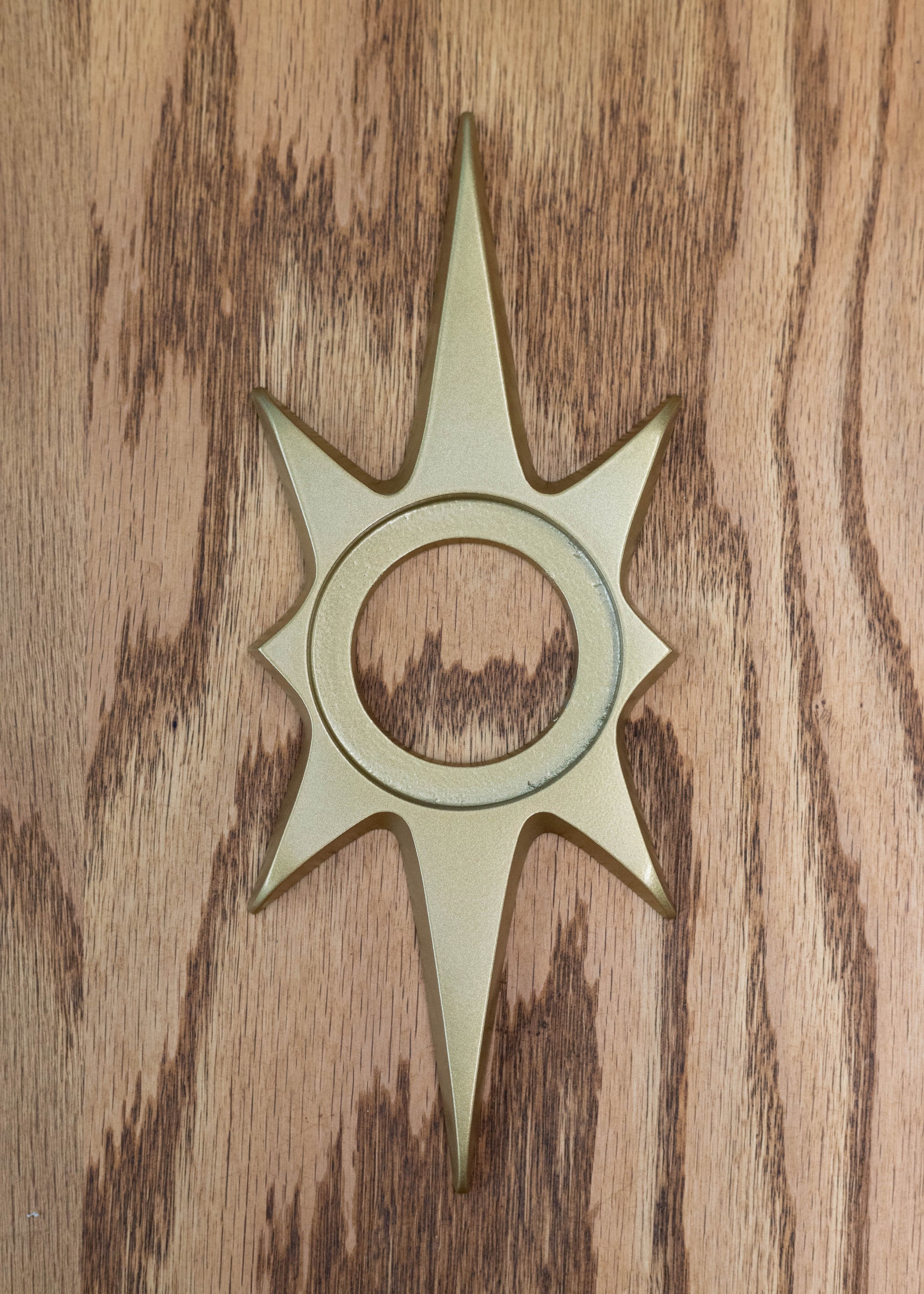 The gold starburst dooknob escutcheon. It has an inset open circle in the center where the doorknob sits and attaches to the door. The gold powder coating is a nice smooth finish. There's a bit of shine, but it's not completely glossy. 