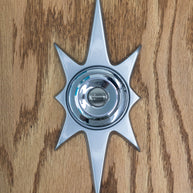 A silver starburst doorknob escutcheon paired with a silver door knob (knob not for sale). It is silver powder coated which gives it a very glossy and smooth finish.The starburst consists of two long points on top and bottom, 2 very short points horizontal, and 4 medium points diagonal.
