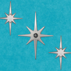 Large three-piece Atomic Starburst door decoration with a 10½-inch aluminum center star and two matching 7½-inch stars.