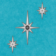 Three handcrafted aluminum Atomic Starbursts arranged on a front door with a 7½-inch center star.