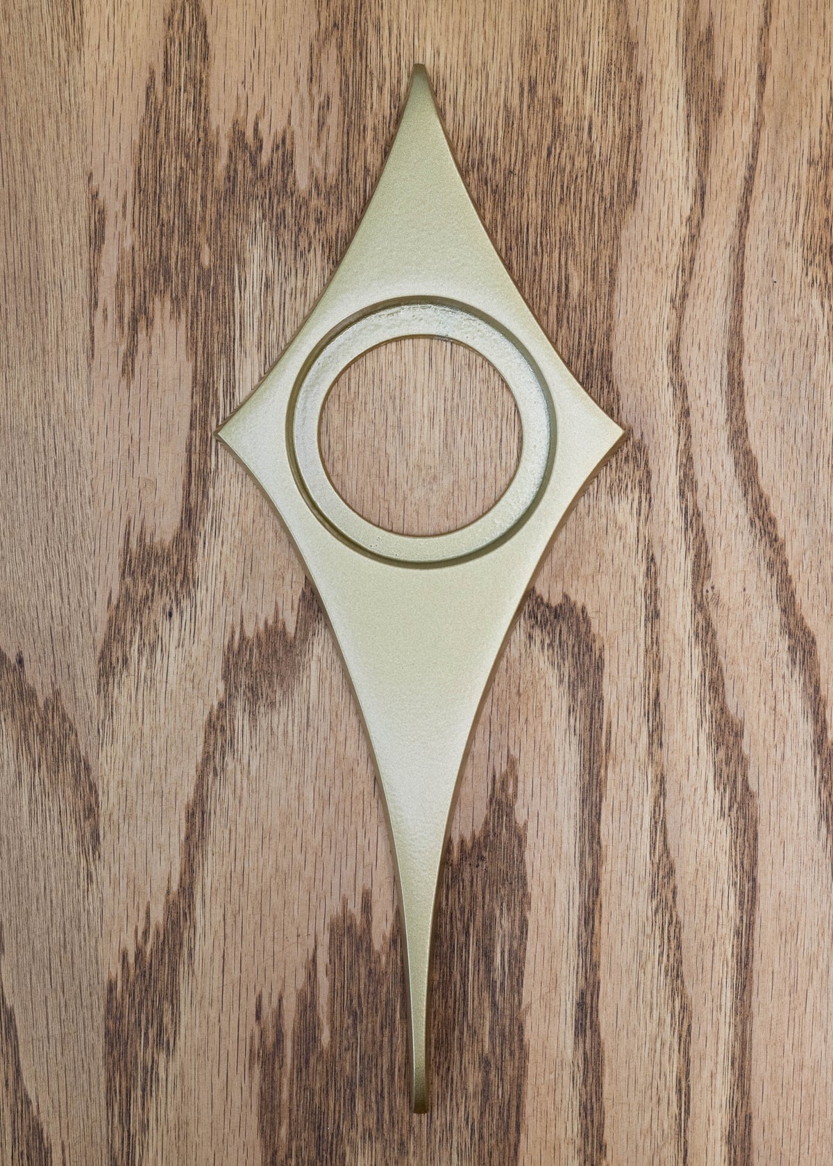 Gold powder coated comet door knob escutcheon. The finish is metallic with a bit of gloss and shine, so the texture is very smooth.