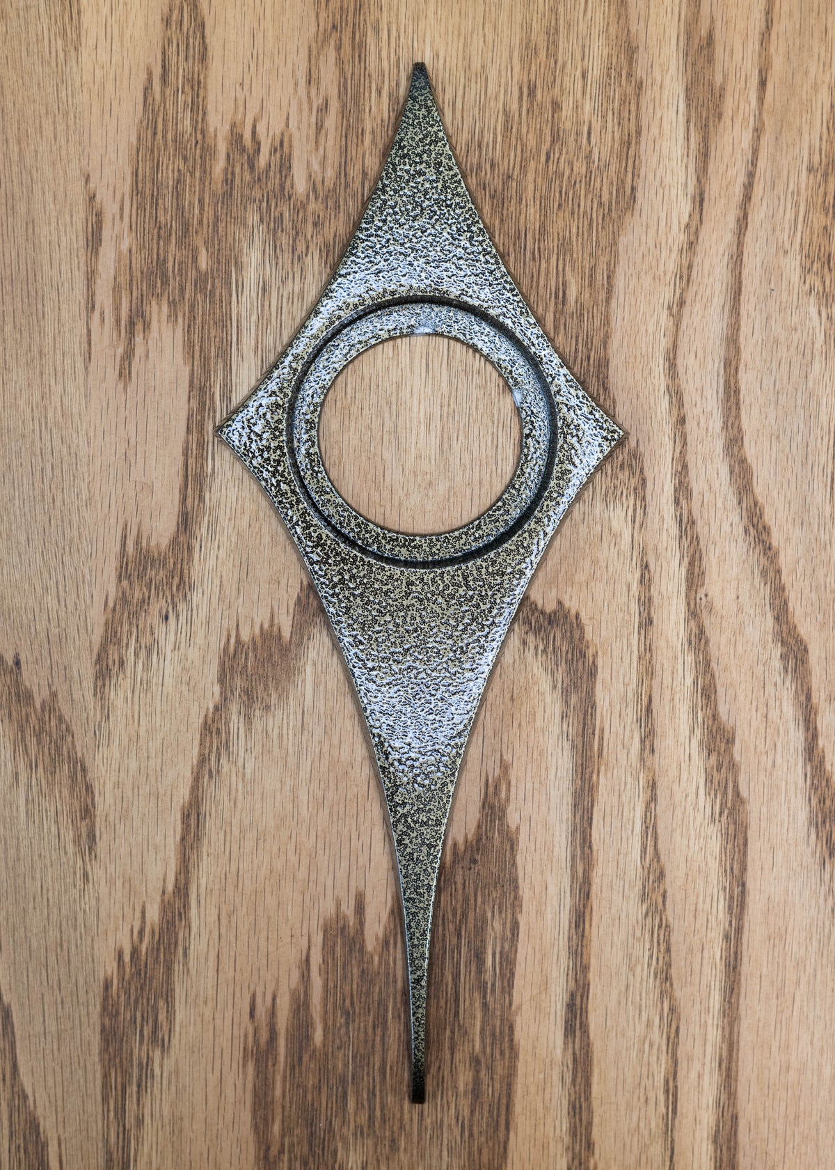 Gold vein powder coated comet escutcheon.  The gold vein is a pitted/ crackled texture that is a mixture of black and gold. It is still smooth and has a glossy finish that reflects light.