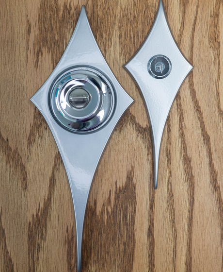 The comet peephole viewer and comet doorknob escutcheon next to each other to compare the sizes. The peephole viewer is about a bit over half the size of the doorknob escutcheon.
