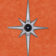 A cast aluminum starburst with a black rubber door stopper in the center. There are three screws: one in the center attaching the rubber stopper to the starburst, and one above and below the stopper for you to attach the starburst to the wall. There is no powder coating, this one is the natural aluminum which is silver in color with a bit of metallic shine to it.