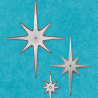 Three handcrafted aluminum Atomic Starbursts in graduated sizes with hammered finishes, arranged on a mid-century modern door.