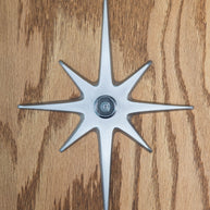 A large cast aluminum starburst with a peephole at the center. This one is natural aluminum with a silver peephole. The natural aluminum is a light silver in color, has a very slight porous texture to it, but is still smooth and gives a matte reflection of light.