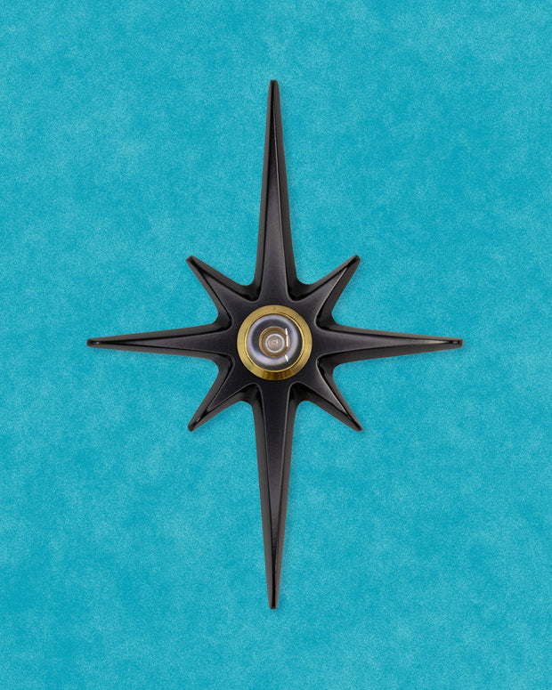 Matte black Atomic Starburst Peephole Viewer with contrasting metallic lens.