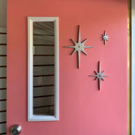 A customer photo with the set of 3 starbursts (without the peephole) on their pink door. They have them arrange with the largest star at the left, the small top right, and medium at the bottom between the two.